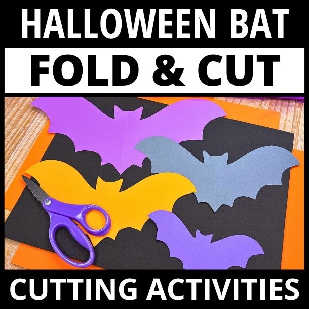 Colorful paper bat shapes in purple, yellow, and black with child scissors on wooden surface, fold and cut activity