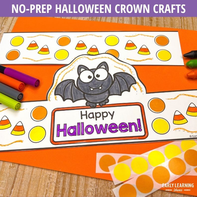 Bat crown craft with candy corn and orange circles to color, surrounded by markers and orange paper strips for assembly
