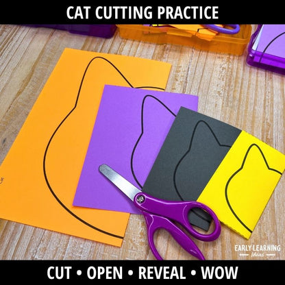 Purple scissors on stacked colored paper sheets with drawn cat outlines for fold-and-cut scissor practice activity.